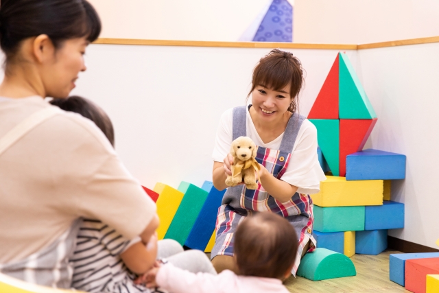子どもと遊ぶ保育士の女性
